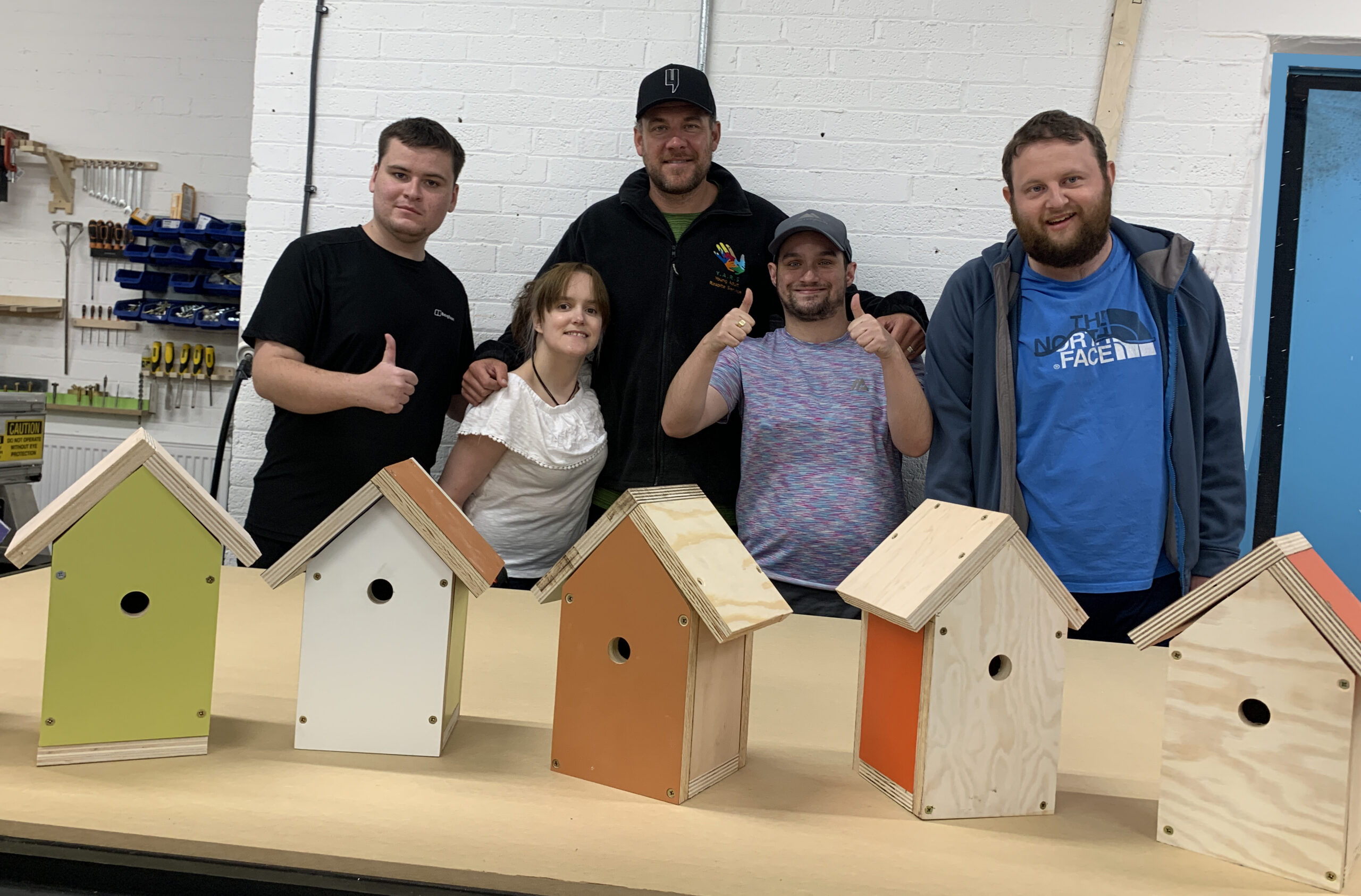 a group of 4 young people and their support worker sharing the bird boxes they made at Urban Workbench Liverpool